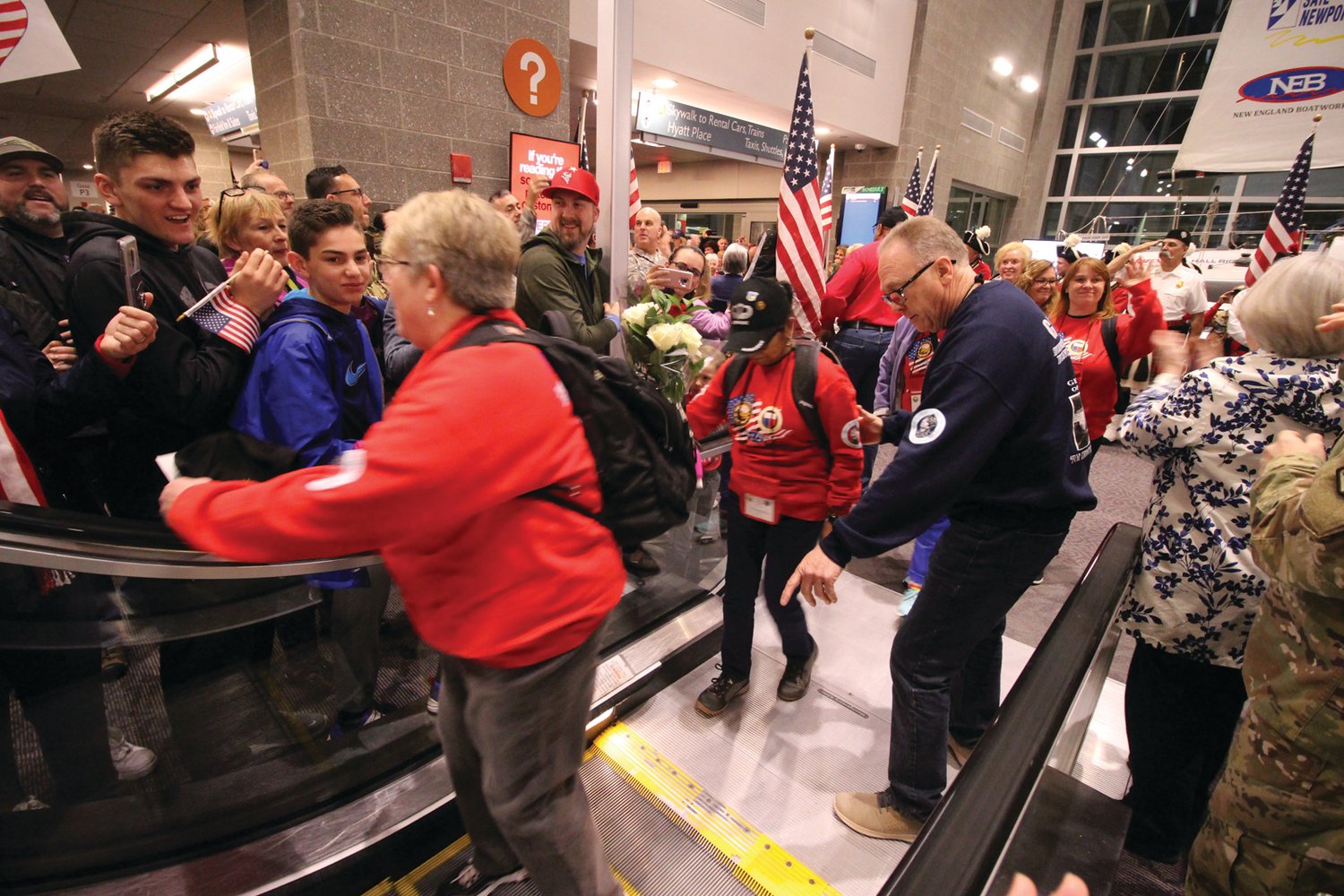 WATCH YOUR STEP: George Farrell assists one of the veterans in the all-women veterans flight hosted by the Federation of Women’s Clubs on April 6, 2019 as they enter the terminal and prepare to board the flight for a full day in Washington, DC. (Herald file photo)